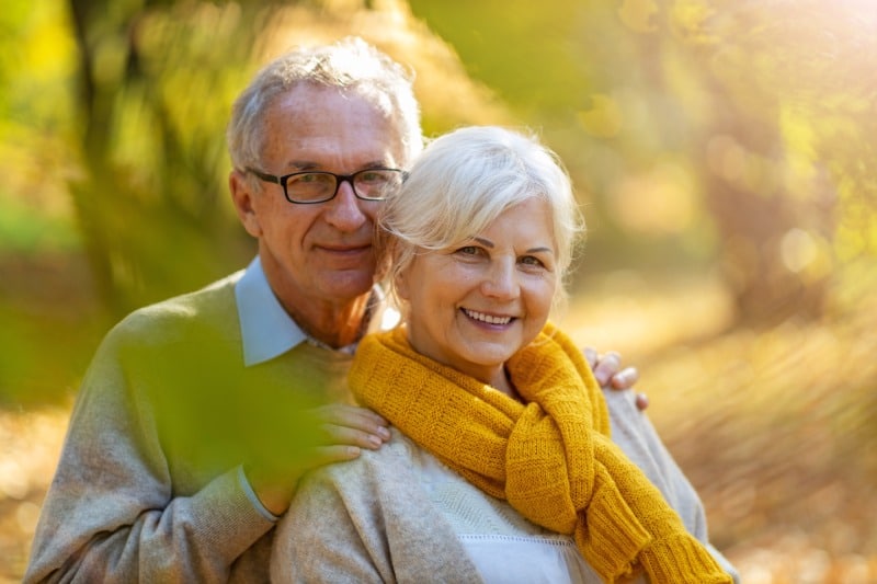 two elderly people posing in a park after securing final expense life insurance